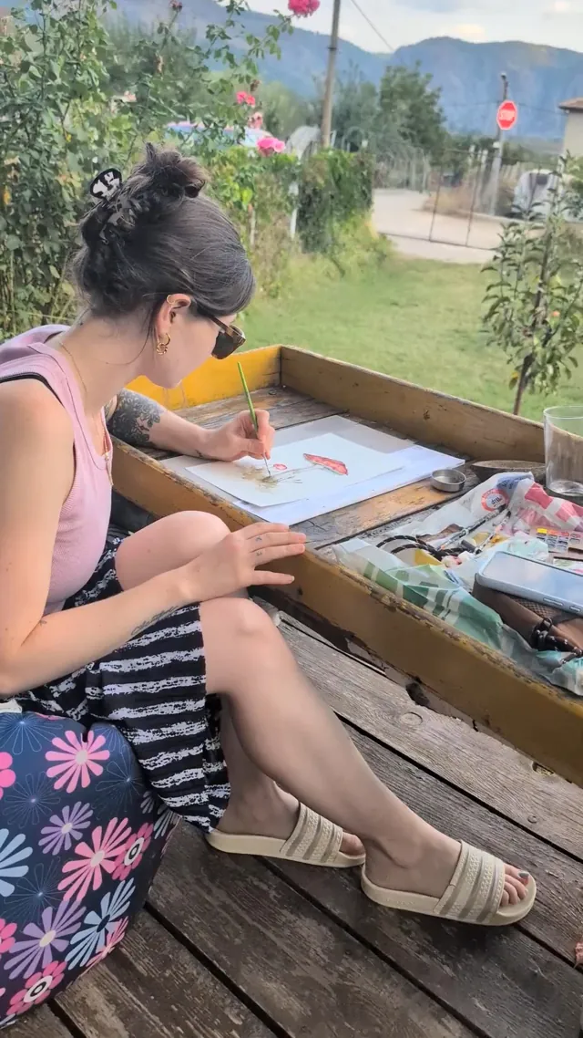 Nicole malt draußen im Garten ein Aquarell