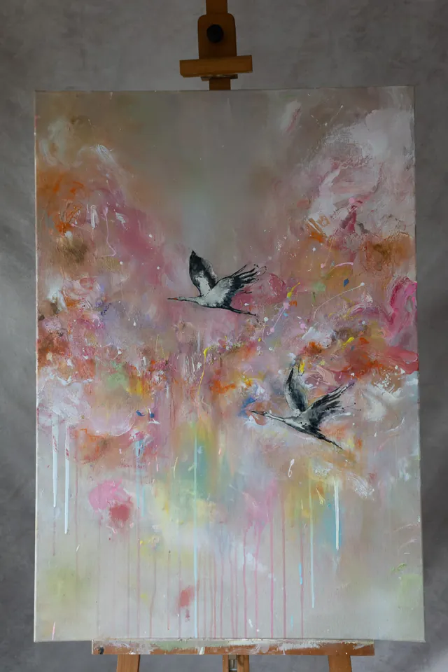 Gemälde Zug der Störche: zwei ziehende Weißstörche in Schwarz und Weiß vor rosa-orangem Wolkenfeld, Acryl auf Leinwand